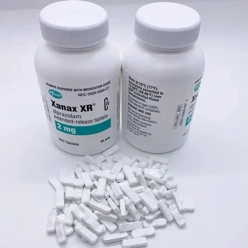 Xanax XR medication, each containing 2 mg of alprazolam. The bottles are white with green and blue labeling that specifies the product as 